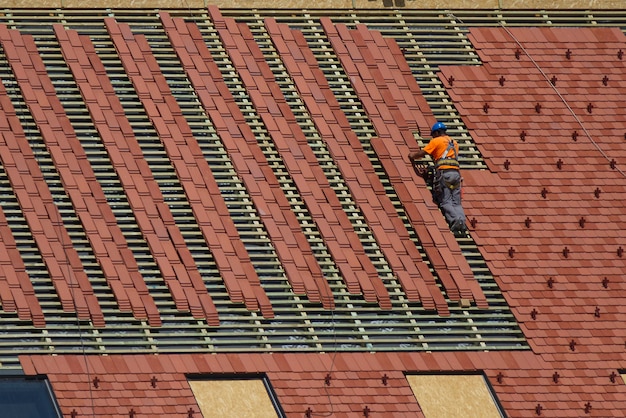 Foto el artesano reparando un techo extendiendo una teja.