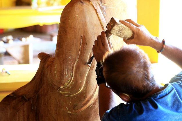 El artesano talla con una hendidura en la mano.