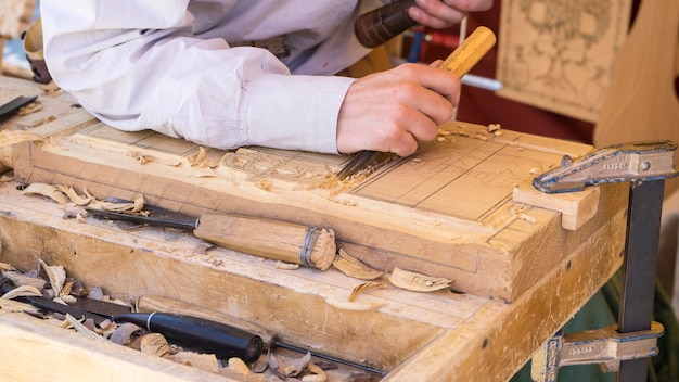 artesano tallando madera en una feria medieval, herramientas de carpintería