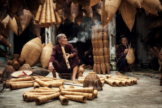 Artesão fazendo armadilha de bambu para peixes no antigo vilarejo de Hung Yen, Vietnã