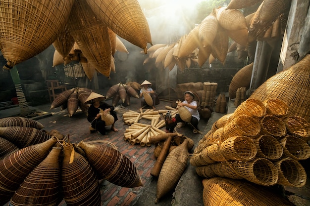 Artesão feminino vietnamita, fazendo a armadilha de peixe de bambu tradicional