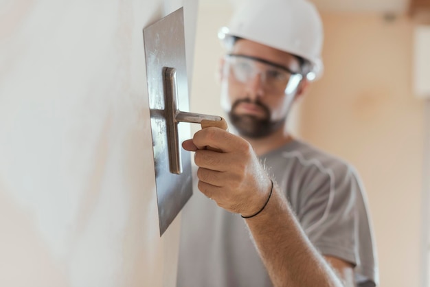 Artesão profissional aplicando gesso com um conceito de renovação de casa com espátula