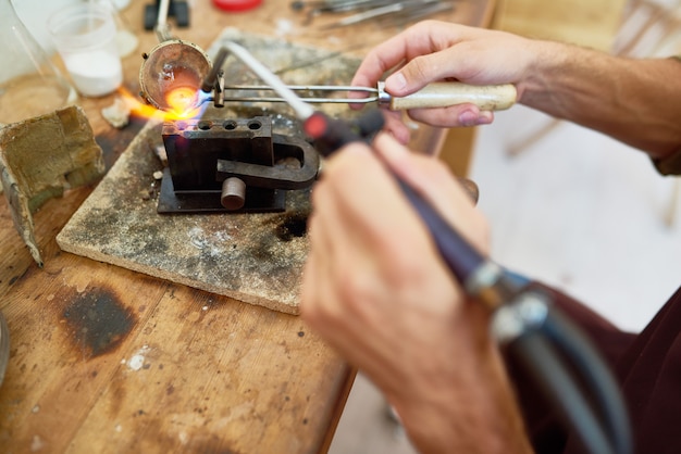 Artesão que derrete o metal na oficina