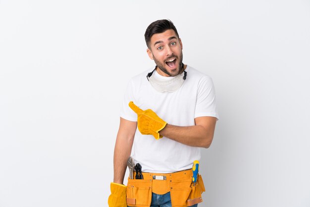 Artesãos ou eletricista homem isolado parede branca apontando o dedo para o lado