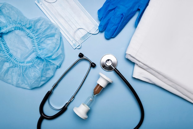 Artículos para el médico jeringa de inyección, guantes, máscara protectora y reloj de arena, estetoscopio.