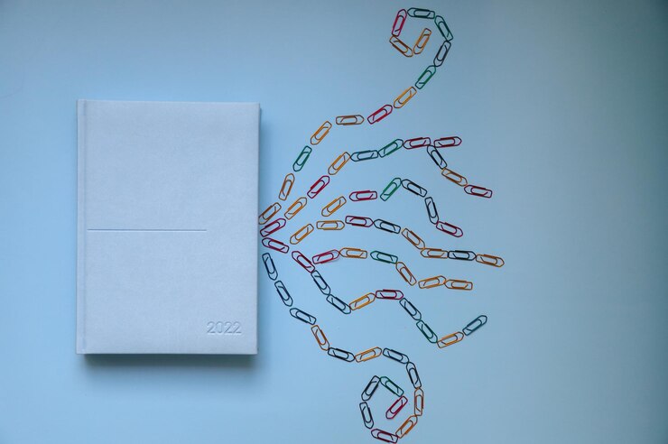 Foto artículos de oficina sobre fondo azul claro planificador anual y clips de papel