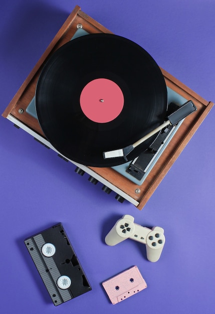 Artículos retro con reproductor de vinilo, cintas de audio y video y gamepad