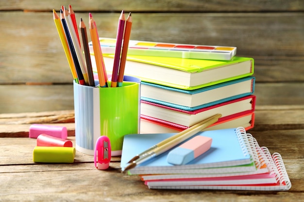 Artigos de papelaria da escola brilhante na velha mesa de madeira