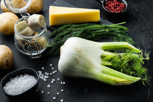 Artischocke mit Fenchel-, Kartoffel- und Parmesanzutaten auf schwarzem strukturiertem Hintergrund