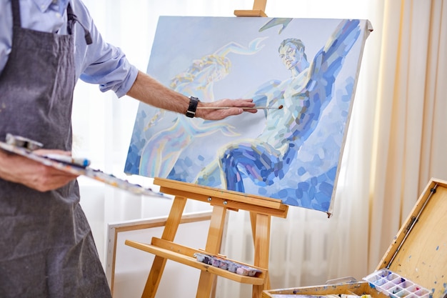 Jovem artista pinta um quadro com um pincel sobre tela, pintando  criatividade. Ilustração por ©derplan13 #418099546
