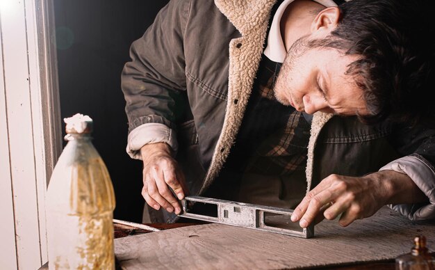 artista artesano masculino con un cepillo procesa un producto de madera