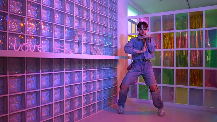 Foto artista asiático se movendo em dança freestyle enquanto olha para a câmera