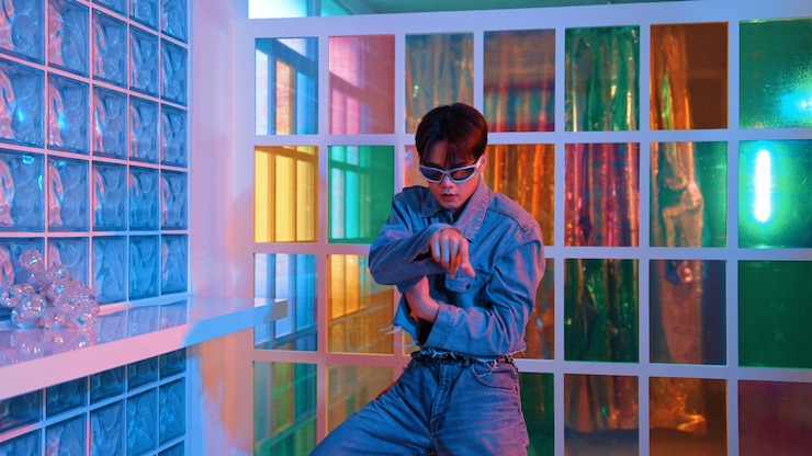 Foto artista asiático se movendo em dança freestyle enquanto olha para a câmera