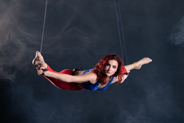 Foto artista de circo aéreo flexible sexy atlético femenino bailando en la seda