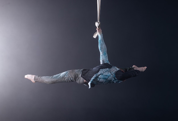 Artista de circo en las correas aéreas con traje.