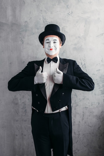 Artista de la comedia masculina posando, pantomima con máscara de maquillaje blanco.