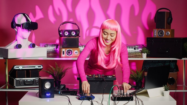 Artista controlando o ritmo da música usando um mixer profissional, curtindo a mistura de sons eletrônicos no clube durante a noite. Artista asiático dançando e tocando techno remix durante o show