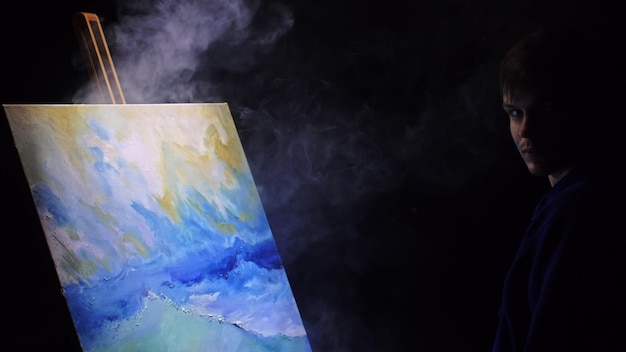 Foto artista copista pintar paisagem marinha com navio no oceano vaper fumaça vape ecigarette artesão decorador desenhar como vela de barco no mar azul com cor de óleo acrílico desenhar paleta de faca de pincel de dedo interior