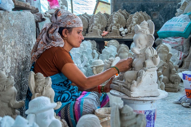 Artista dá toques finais em um ídolo do deus hindu Lord Ganesha em uma oficina de artista para o festival Ganesha