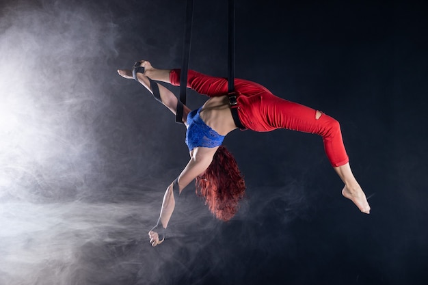 Artista de circo aéreo flexível sexy atlética feminina dançando na seda