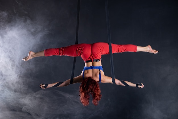 Artista de circo aéreo flexível sexy atlética feminina dançando na seda