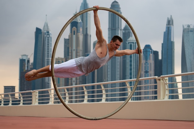 Artista de Cyr Wheel com vista da cidade de Dubai durante o pôr do sol.