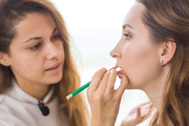 Artista de maquiagem fazendo maquiagem profissional em uma jovem