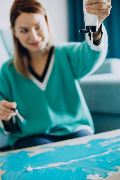 Artista de mulher pintando um quadro em casa