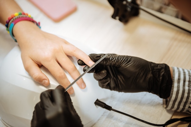 Artista de unhas. adolescente estilosa e moderna usando pulseiras brilhantes indo para a unha artista depois da escola