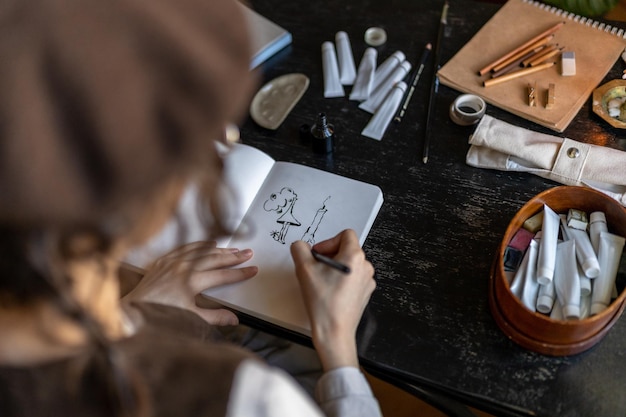 Artista desenhando com tinta preta em papel branco