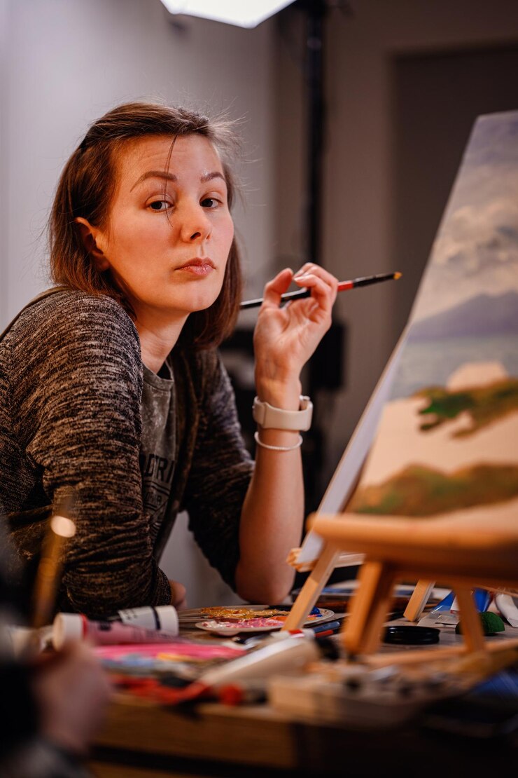 Foto un artista se detiene pensativo mientras trabaja en la pintura de paisajes