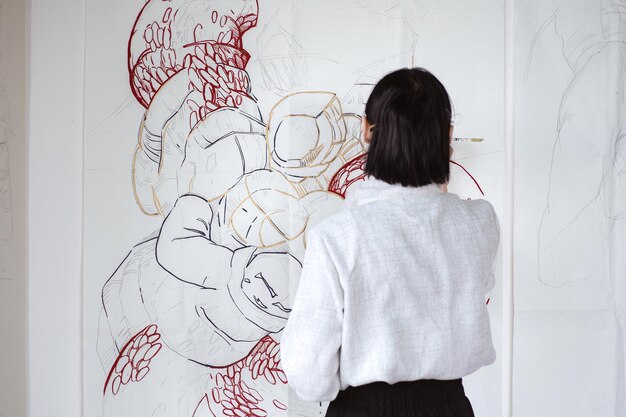 Artista femenina dibujando pintura con pincel y pintura negra Pintura gráfica Creación de arte moderno