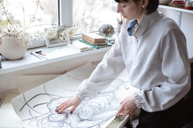 Artista femenina dibujando pintura con pincel y pintura negra Pintura gráfica Creación de arte moderno