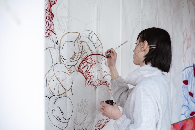 Artista femenina dibujando pintura con pincel y pintura negra Pintura gráfica Creación de arte moderno