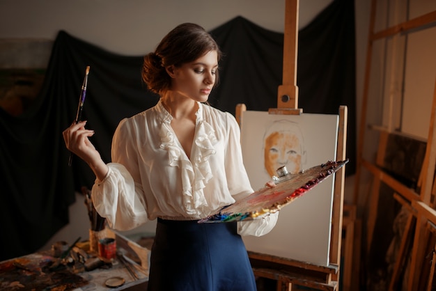 Artista femenina con paleta de colores y pincel