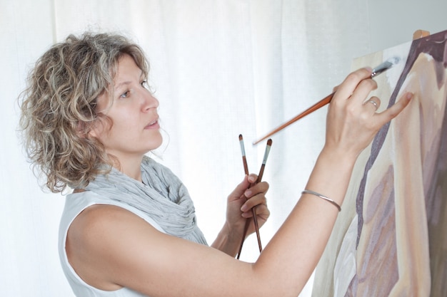 Artista femenina pintando un cuadro.