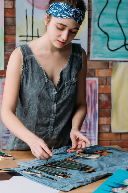 Artista femenina pintando en el espacio de trabajo creativo