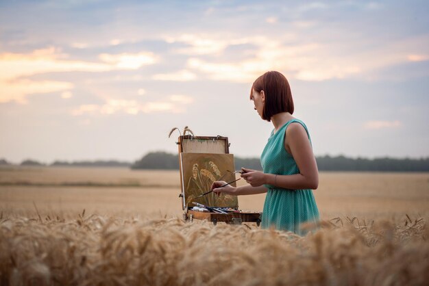 Artista femenina profesional trabajando en el campo de centeno.