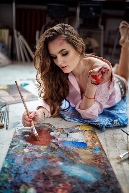 Foto artista femenina trabajando en pintura en studiox9