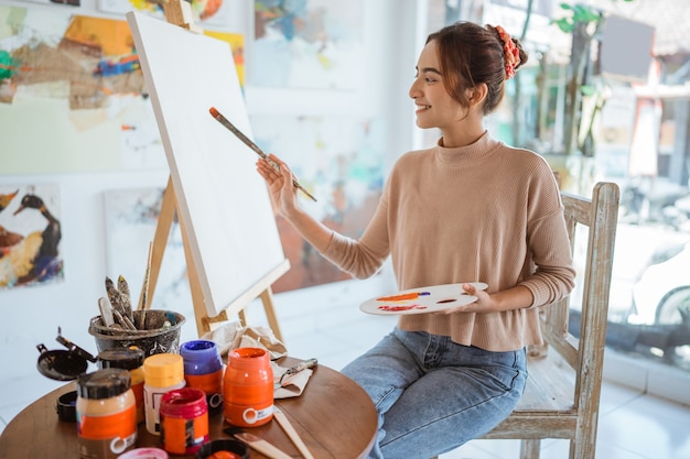 Artista femenina trabajando en su pintura en el estudio