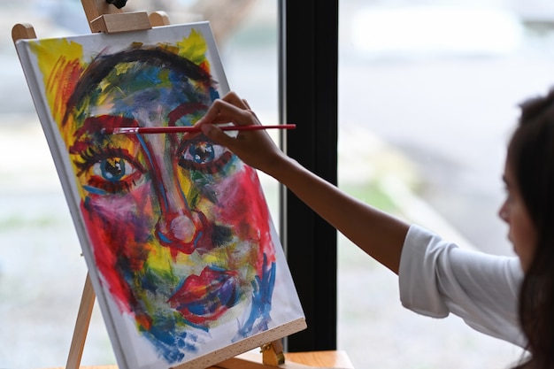 Foto artista feminina asiática pintando obras de arte em seu espaço de trabalho.