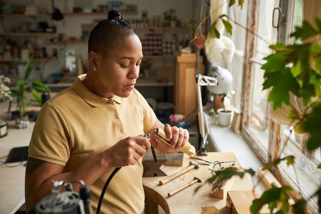 Artista feminina negra trabalhando em joias