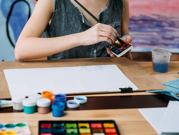 Artista feminina pintando em um espaço de trabalho criativo