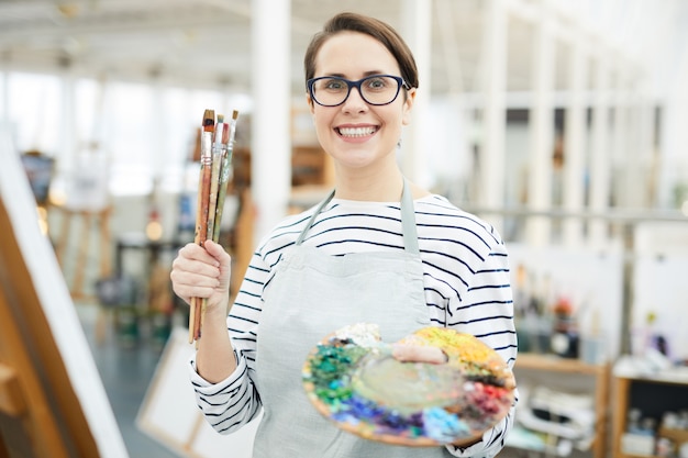 Foto artista feminina sorridente segurando a paleta