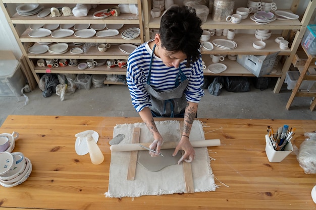 Artista francesa femenina trabaja con arcilla en una mesa de cerámica en un espacio de arte creativo