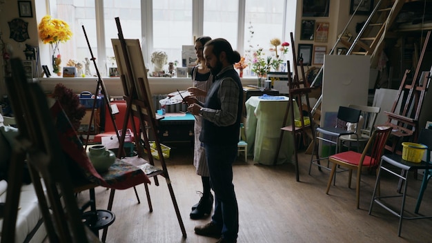 Artista habilidoso ensinando jovem a desenhar pinturas e explicando o básico na aula de arte