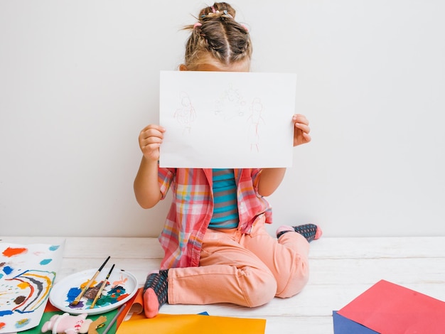 Artista incerto Menina tímida Garoto inseguro pintura fundo branco Conceito de timidez de educação infantil