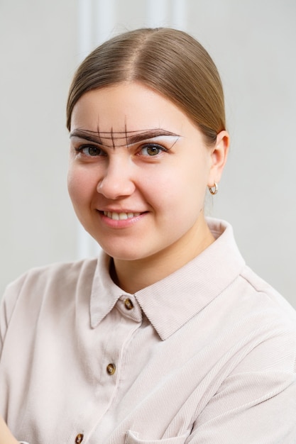 Artista de maquillaje aplica tinte de cejas para el maquillaje permanente de una niña. Maquillaje profesional y cuidado cosmético facial.