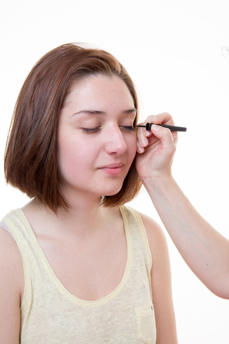 Foto artista de maquillaje aplicando delineador líquido con pincel, de cerca