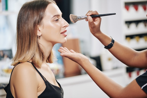 Artista de maquillaje aplicando polvo de acabado